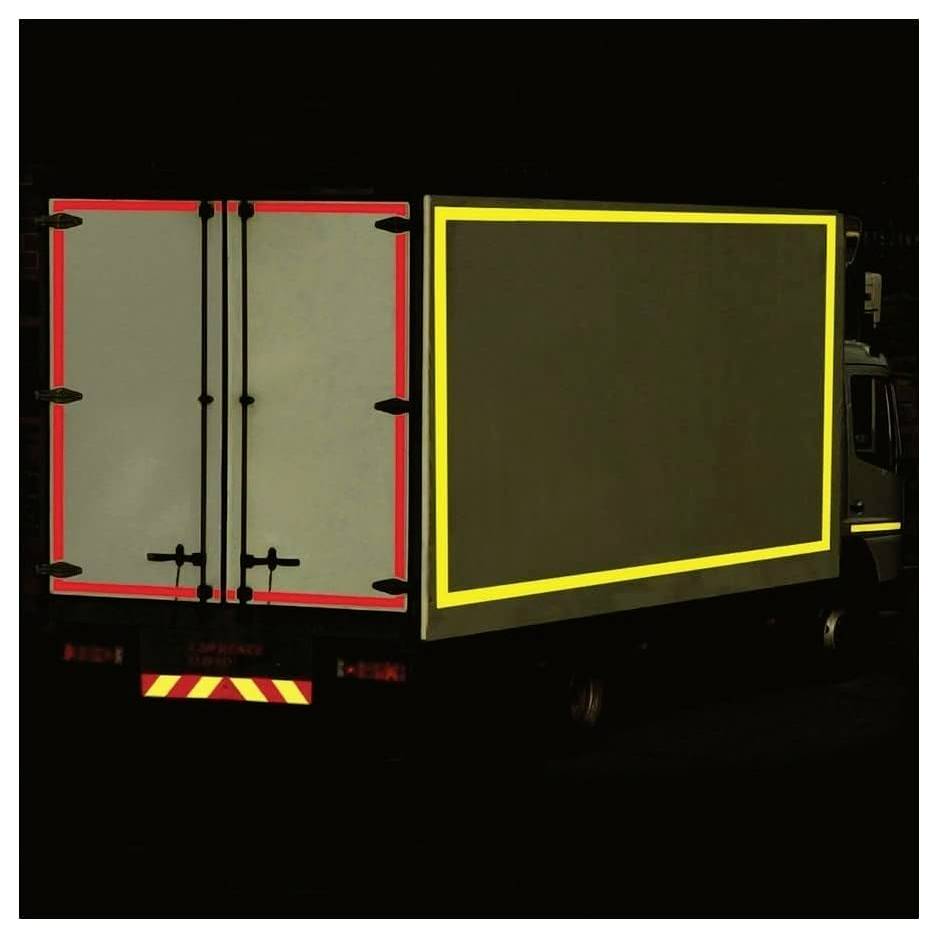 A truck with visible red and yellow reflective strips on the back and sides, enhancing its visibility in dark conditions.