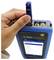 A hand inserts a network cable into a blue device displaying 'Link Qualification' on the screen, with several connection ports visible.