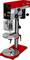 A red and grey bench drill press with a digital display, adjustable arm, and safety cover for woodworking or metalworking tasks.
