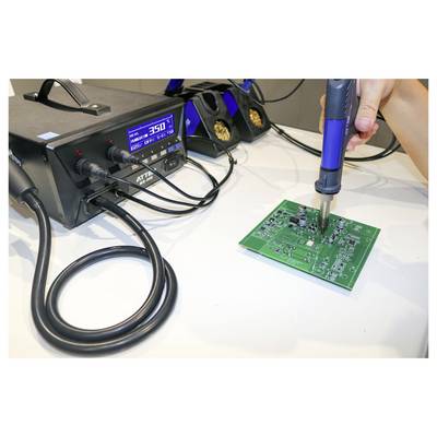 A hand uses a soldering iron on a green circuit board, connected to a digital soldering station displaying a temperature of 350 degrees.