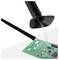 Soldering iron with smoke extractor removing fumes while working on a green circuit board with electronic components.
