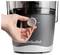 A hand adjusts the dial on a Nutribullet blender, turning it from 'OFF' towards 'LOW'. The appliance base is dark gray with 'Nutribullet' logo.