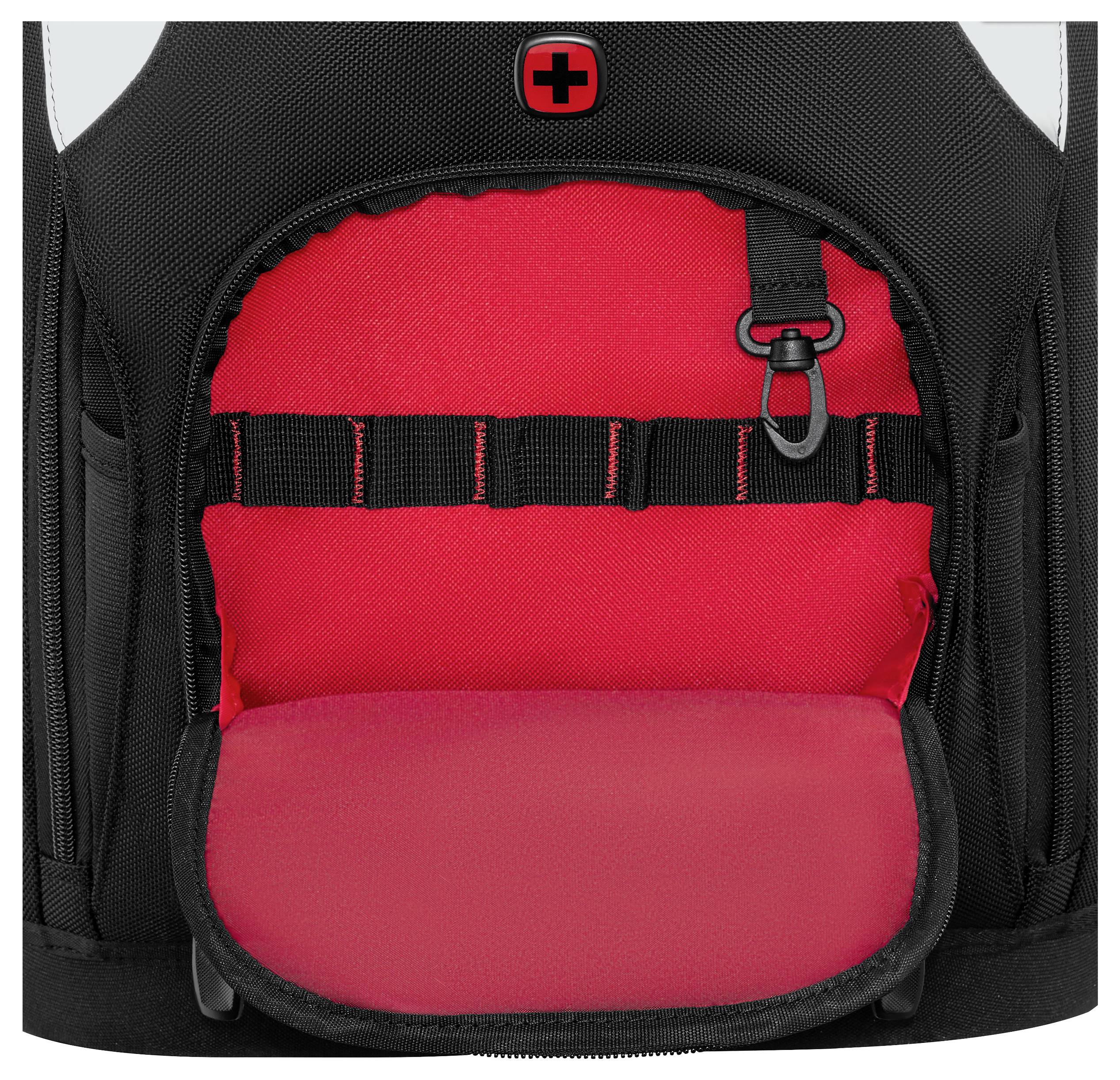 A black backpack with a red interior is open, showing a Swiss symbol on top and black straps inside for organization.