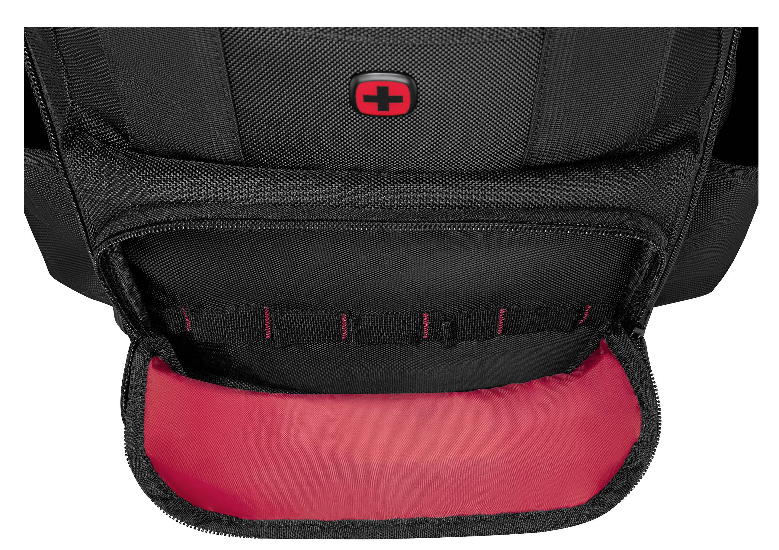 A black backpack features a large zippered compartment lined with red fabric, showcasing storage space. A red logo is visible on the flap.