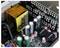 Inside view of a computer circuit board showing capacitors, resistors, and circuitry. Key components are neatly arranged.
