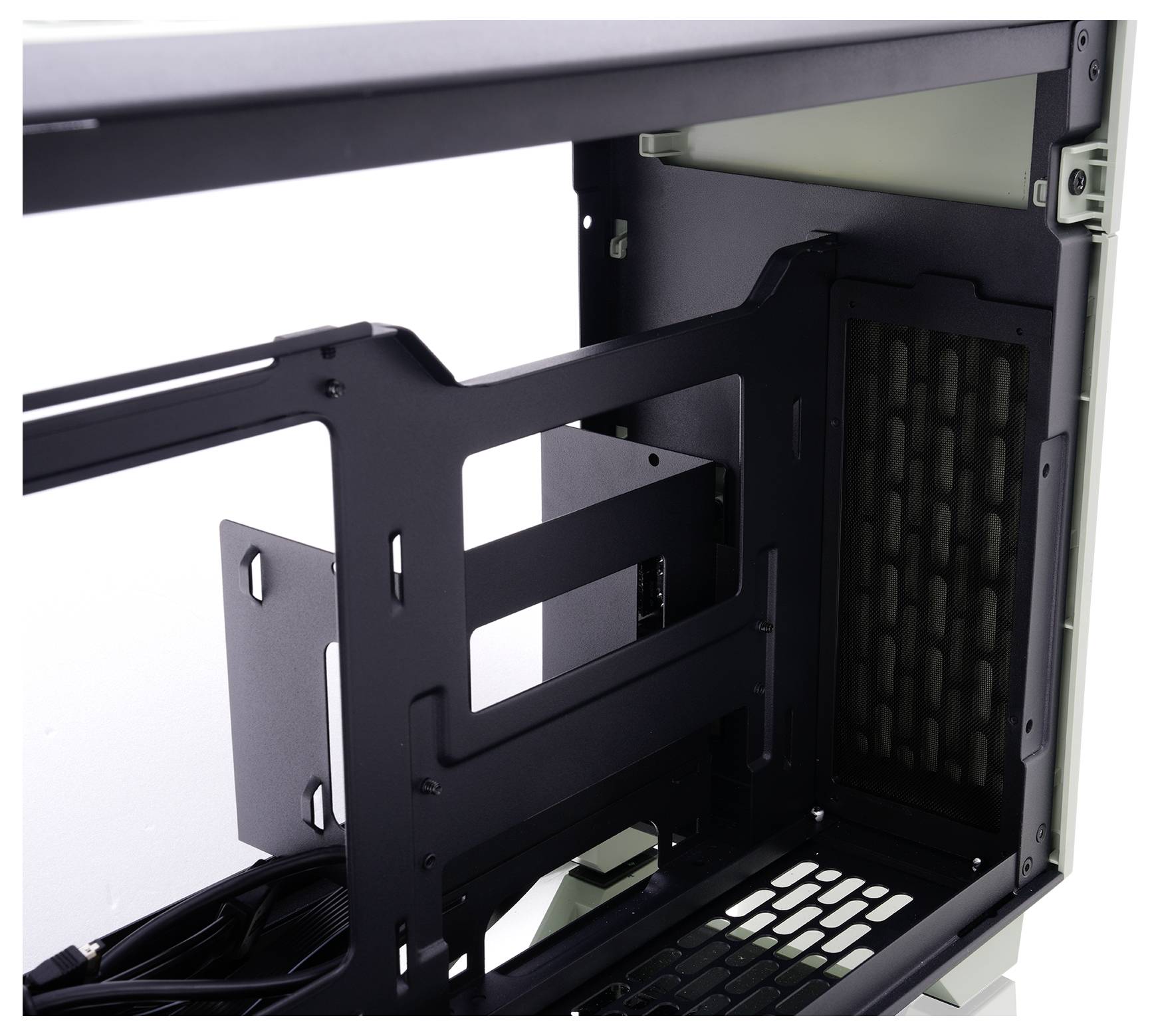 A black and white computer case interior, showing an empty frame, cable slots, and a grid side panel, ready for components installation.