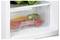 'A refrigerator vegetable drawer with fresh vegetables including a yellow pepper, zucchini, red pepper, and tomato inside.'