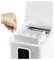 A hand lifts the ice tray from a white countertop ice machine, revealing three ice cubes inside. The lid is open, showing the interior.