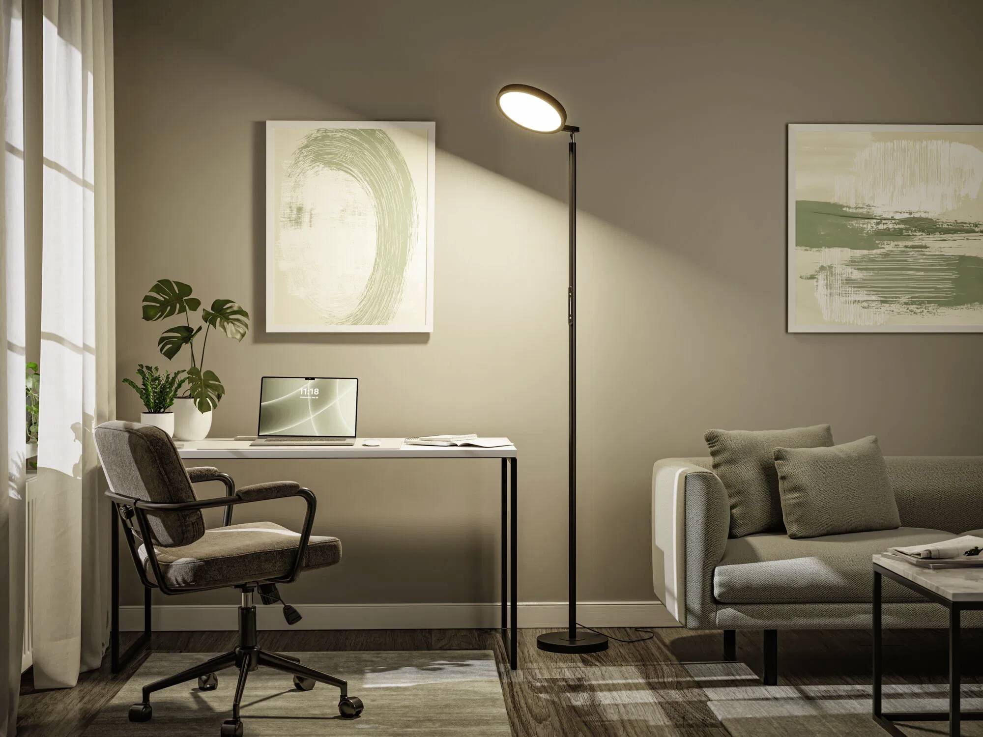 A modern living room with a floor lamp, a desk with a laptop, an office chair, a sofa, and abstract art on the walls. Relaxed and organized space.