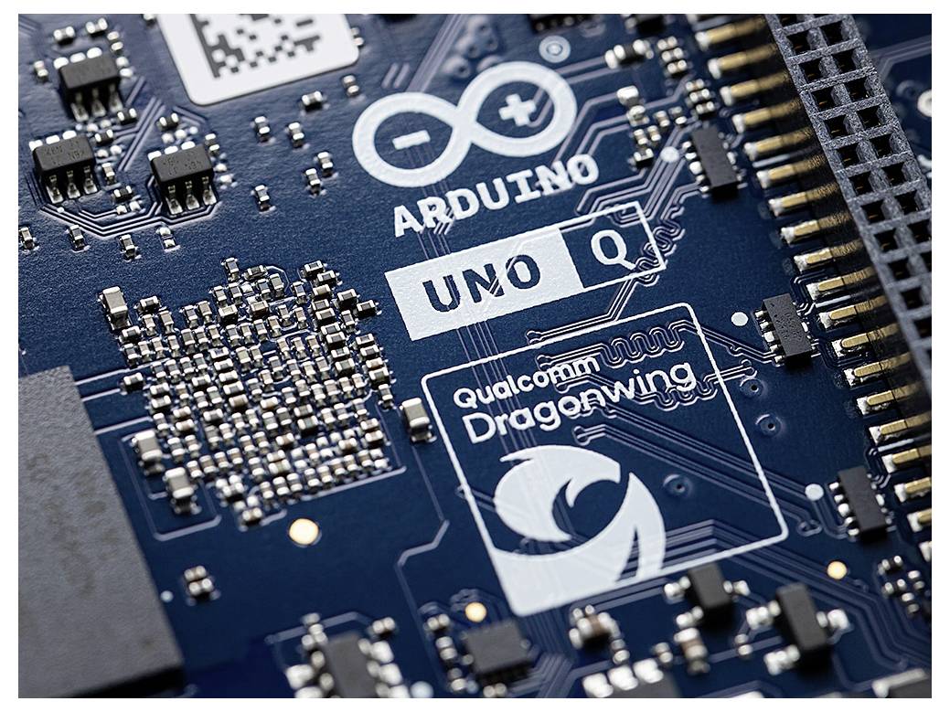 Close-up of a circuit board featuring logos 'Arduino UNO Q' and 'Qualcomm Dragonwing'. The board is populated with various electronic components.