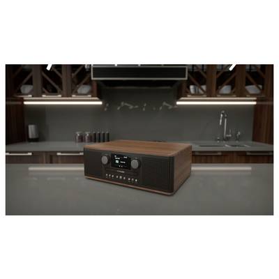 A wooden digital radio with a display and control knobs sits on a modern kitchen countertop, with sleek cabinets and a sink in the background.
