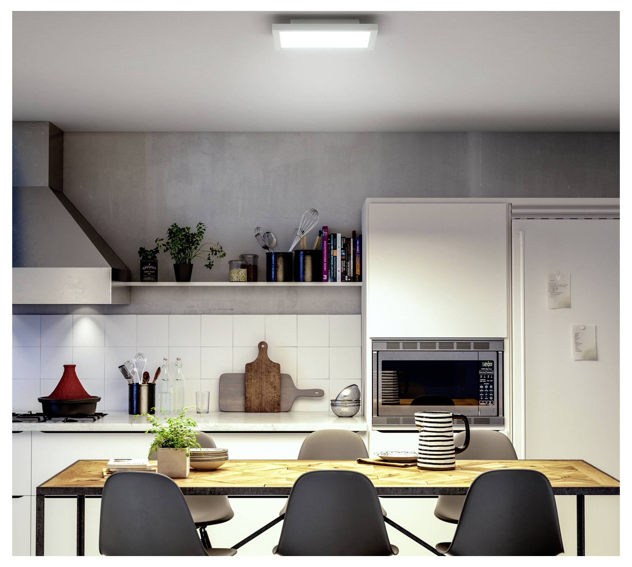 A modern kitchen with a wooden dining table set for four. Shelves hold plants and kitchen items. An oven is built into white cabinets.