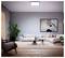 A modern living room with a large beige sectional sofa, abstract wall art, houseplant, and wooden coffee table on a white rug.