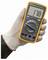 'A hand in a glove holds a digital multimeter displaying 17.8. The multimeter has various settings and an orange protective cover.'