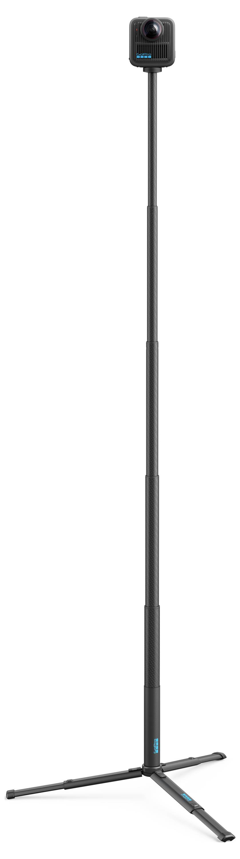 'Tall, black camera tripod fully extended with a camera mounted on top, standing on a white background.'