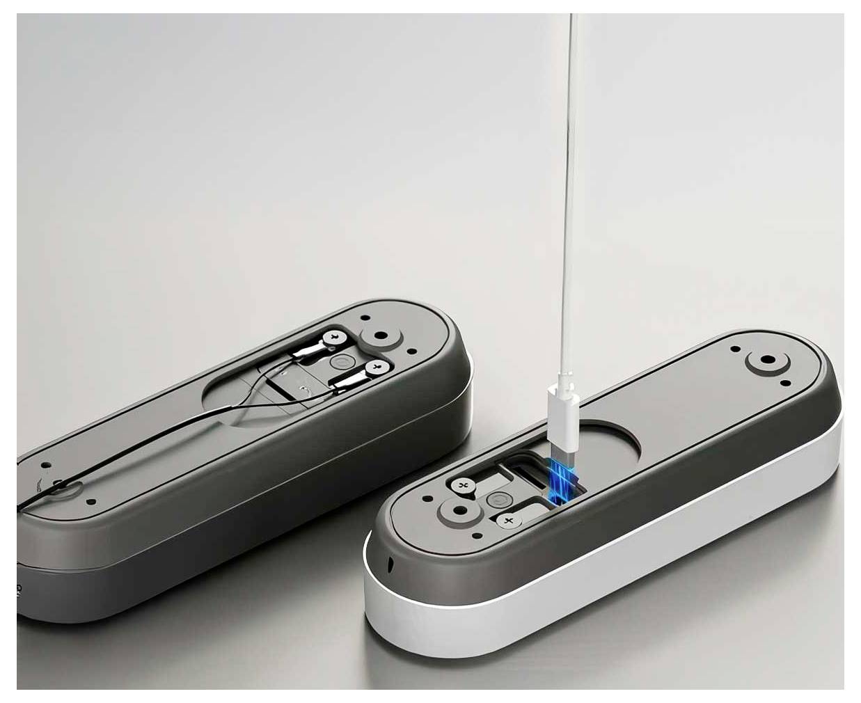 Two elongated, sleek devices are shown. One is open, revealing internal components, while the other is closed, with a cable inserted.