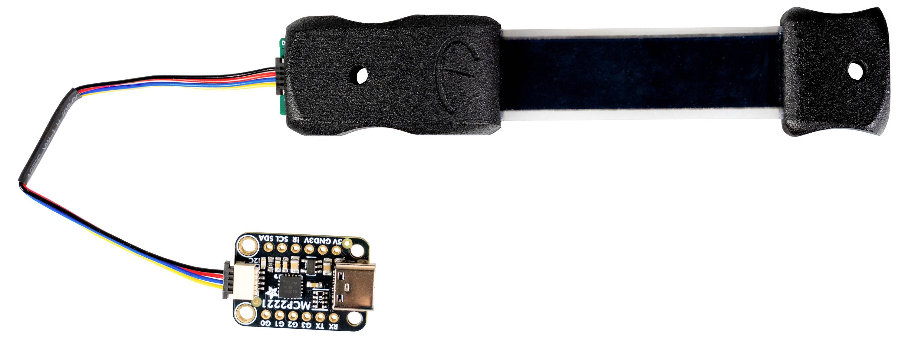 A digital microcontroller connected to a flexible printed circuit board by multicolored wires, used for electronic projects or prototypes.