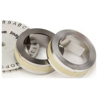 Two circular metal parts, each with a coiled strip inside, lie beside a round disc with alphanumeric markings. These items are likely components of a mechanical device.