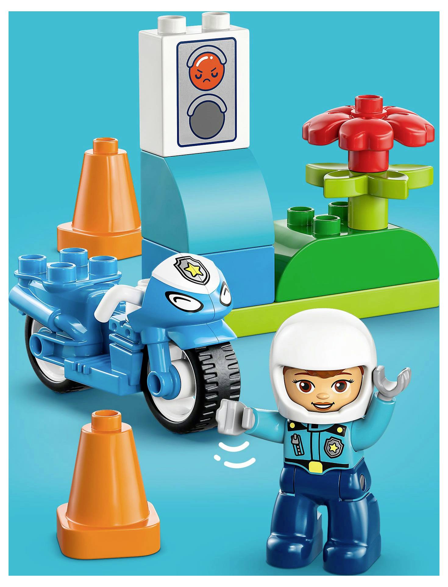 A toy figure in a police uniform waves near a blue toy motorcycle, orange cones, and a traffic light with a red signal.