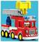 A children's toy fire truck made of building blocks, featuring a red truck with a smiling figure in a firefighter helmet in the driver's seat.