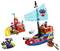 A colorful toy pirate ship set with a sail featuring a spider emblem, part of a themed playset including a slide and small boat.