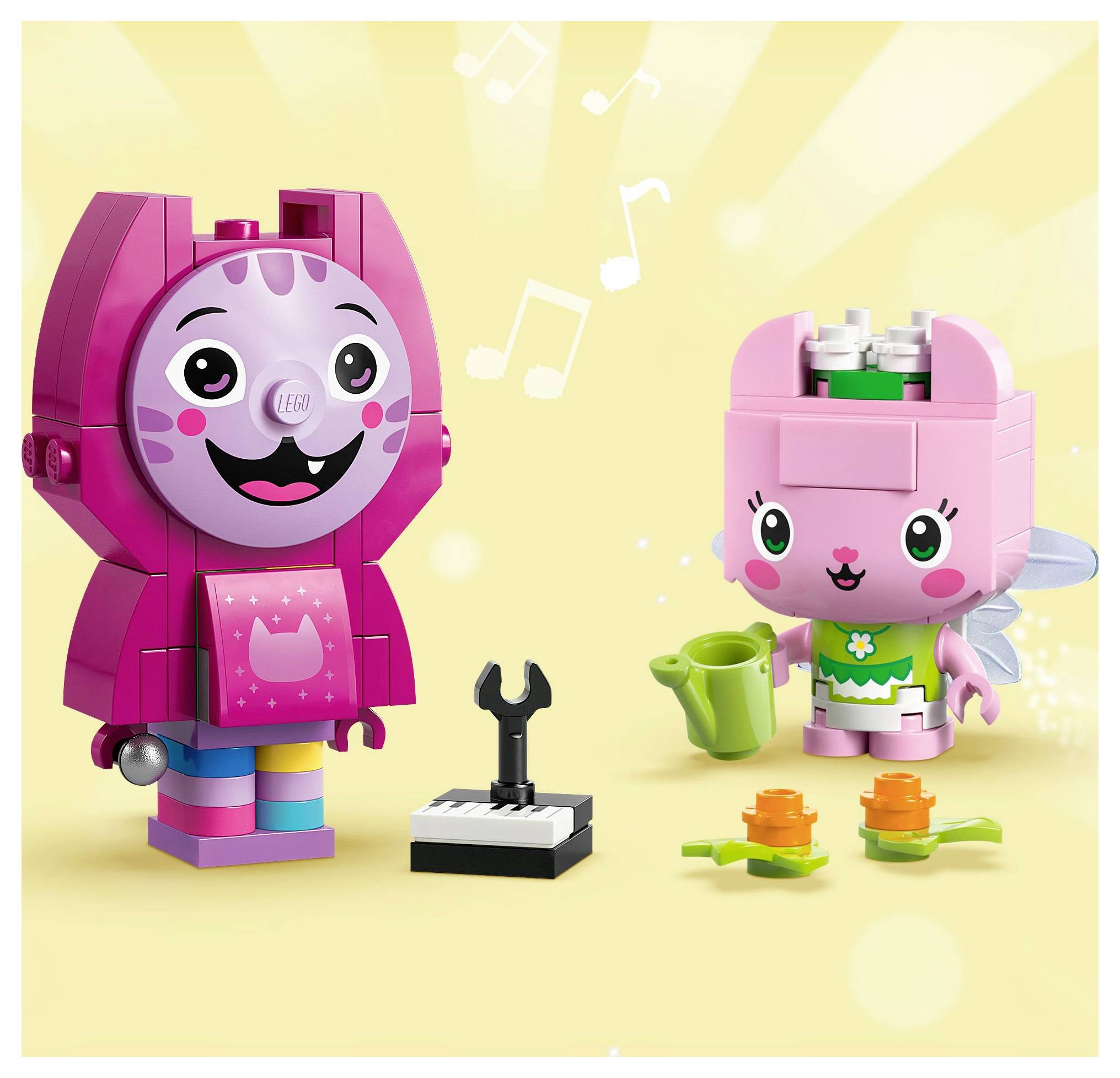 Two colorful block figures: a tall pink one with cat-like features and a smaller pink fairy figure holding a watering can, with flowers nearby.