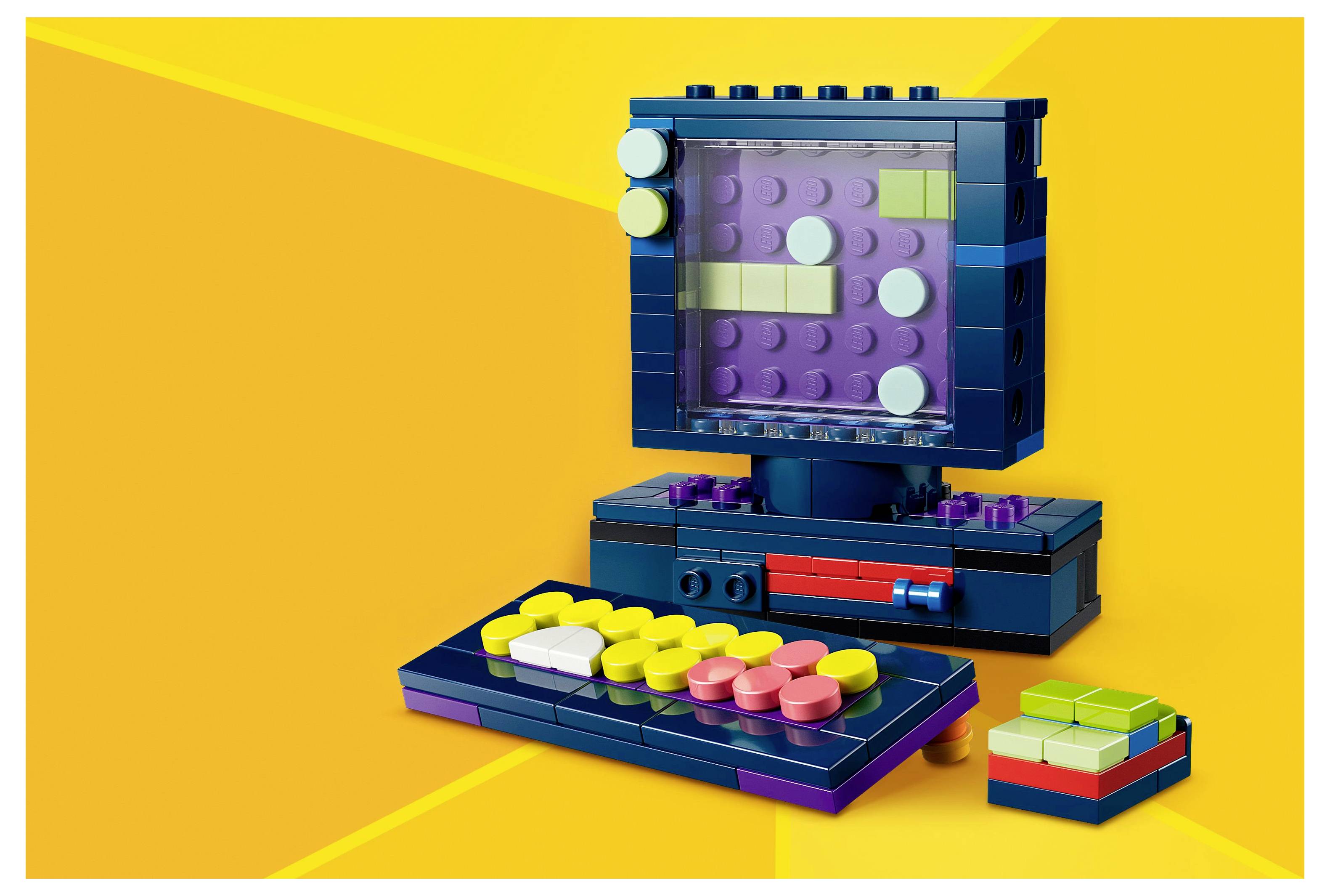 A colorful block toy set resembling a retro computer with a keyboard on a vibrant yellow background.