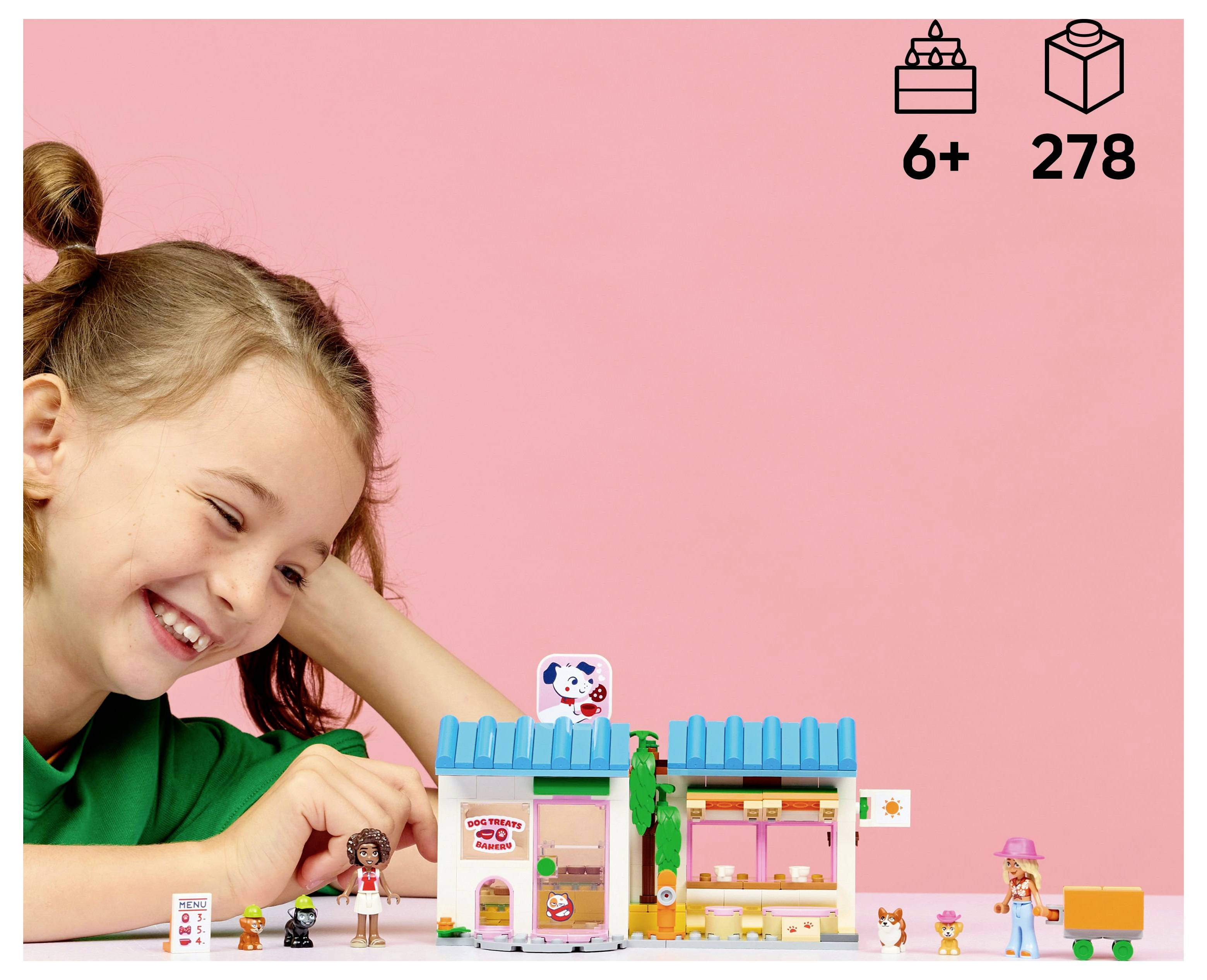 A child plays with a colorful toy set featuring a toy store, figures, and accessories on a pink background. Suitable for ages 6+, 278 pieces.