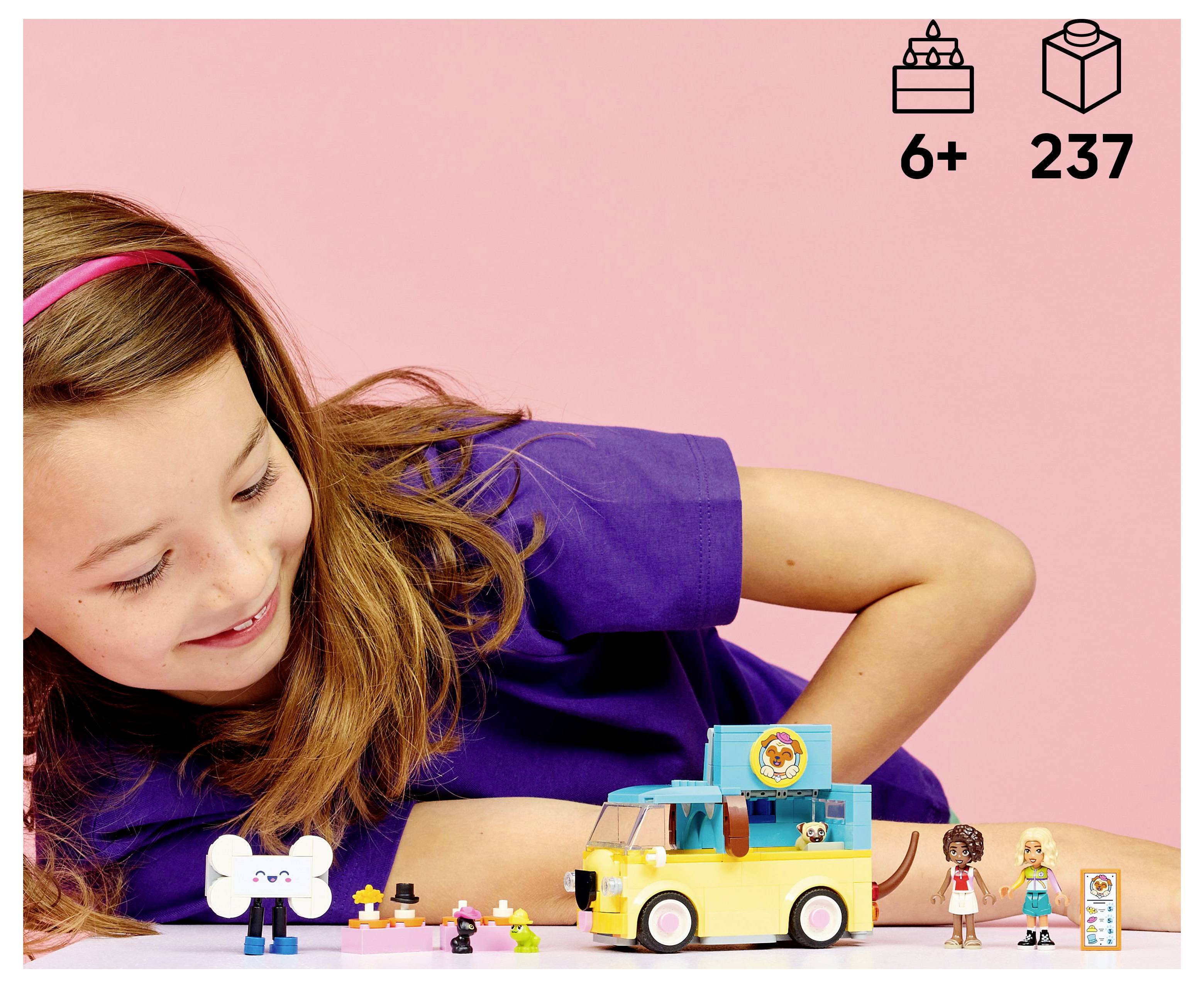 A child smiling at a toy ice cream truck set, featuring figures and small accessories, against a pink background with '6+' age and '237' pieces icons.