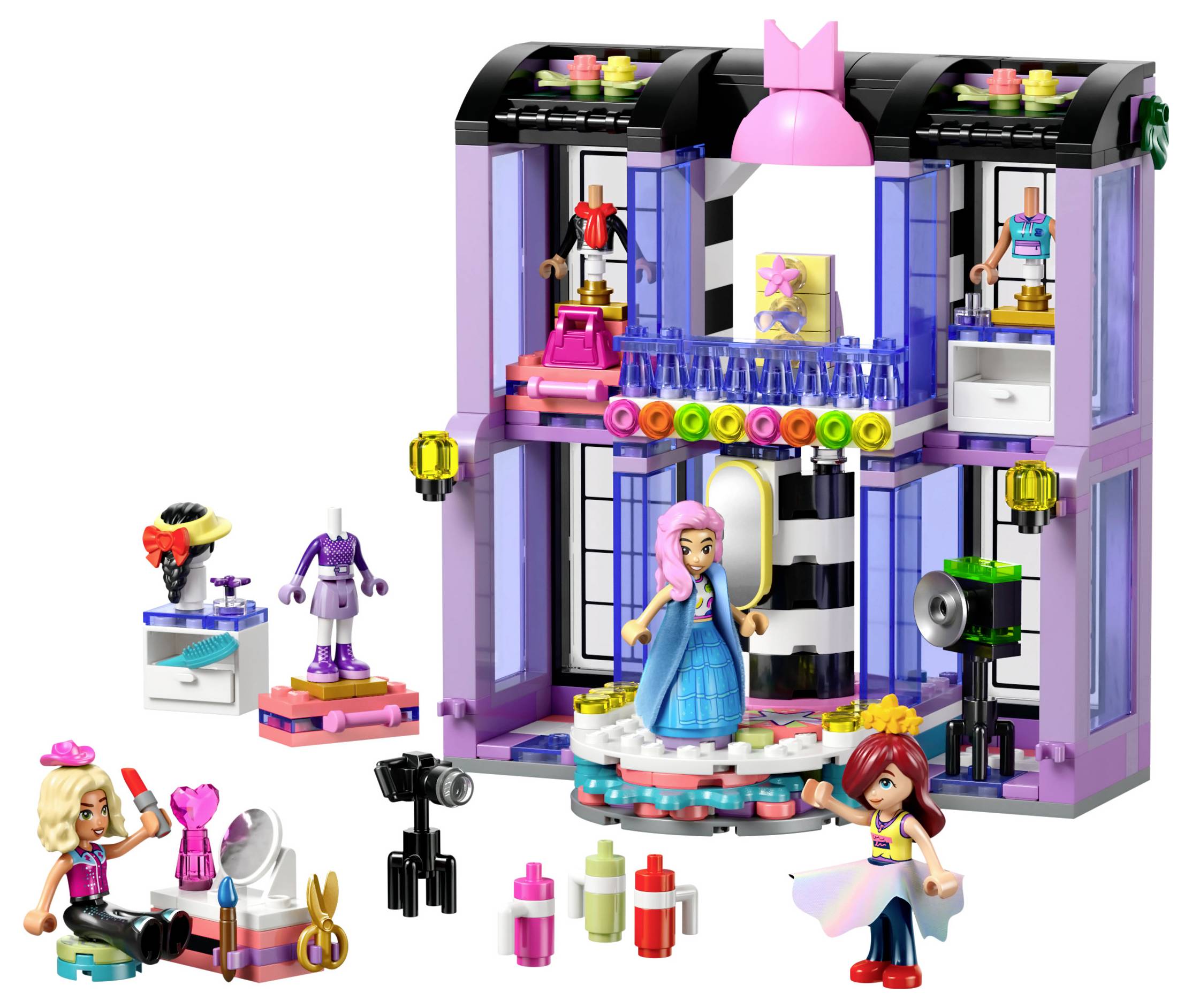 A colorful toy fashion studio with two figures, fashion accessories, a stage with lights, and various styling tools.