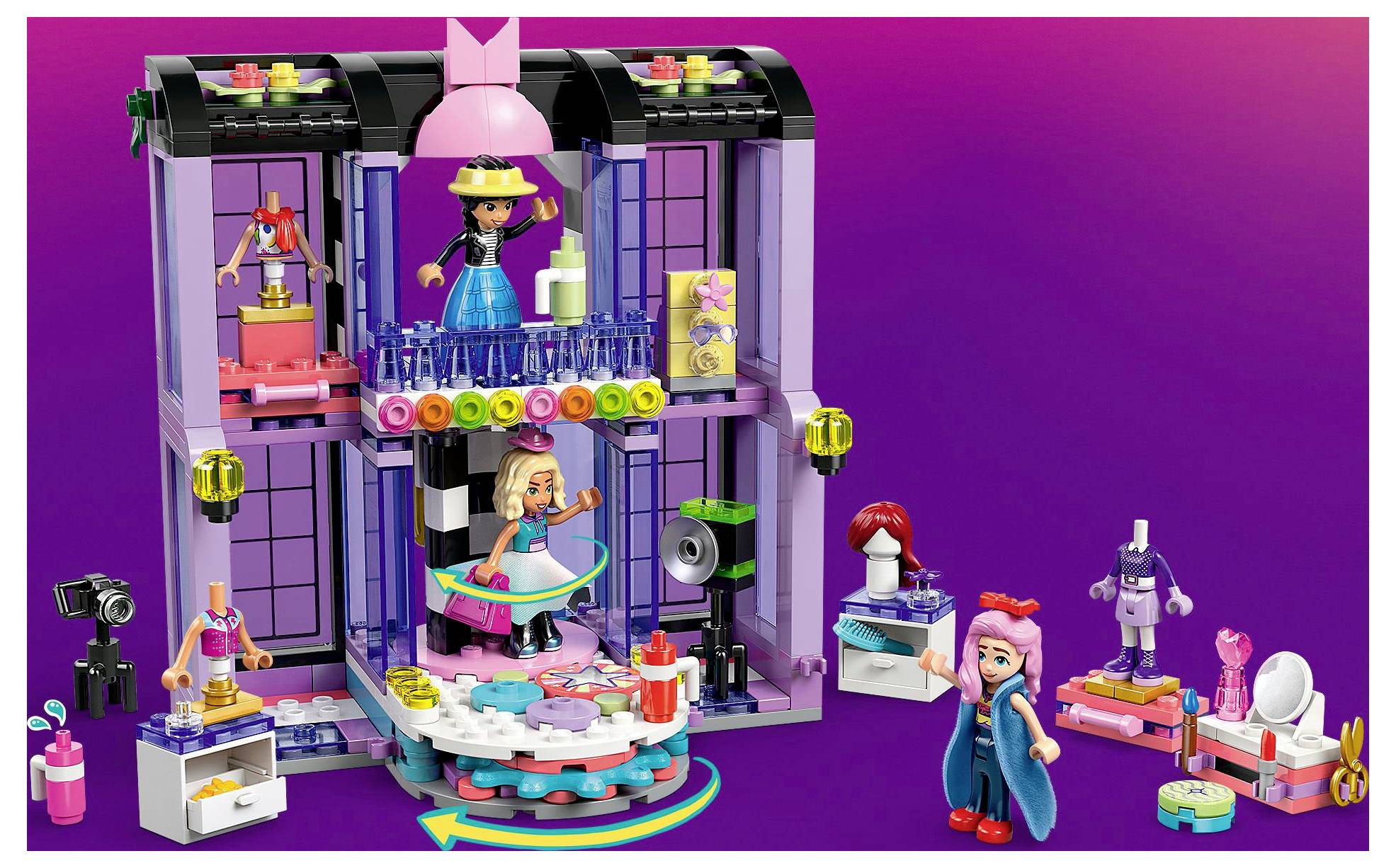A colorful toy set featuring a two-level fashion studio with figures creating outfits, accessories, and working on design elements.