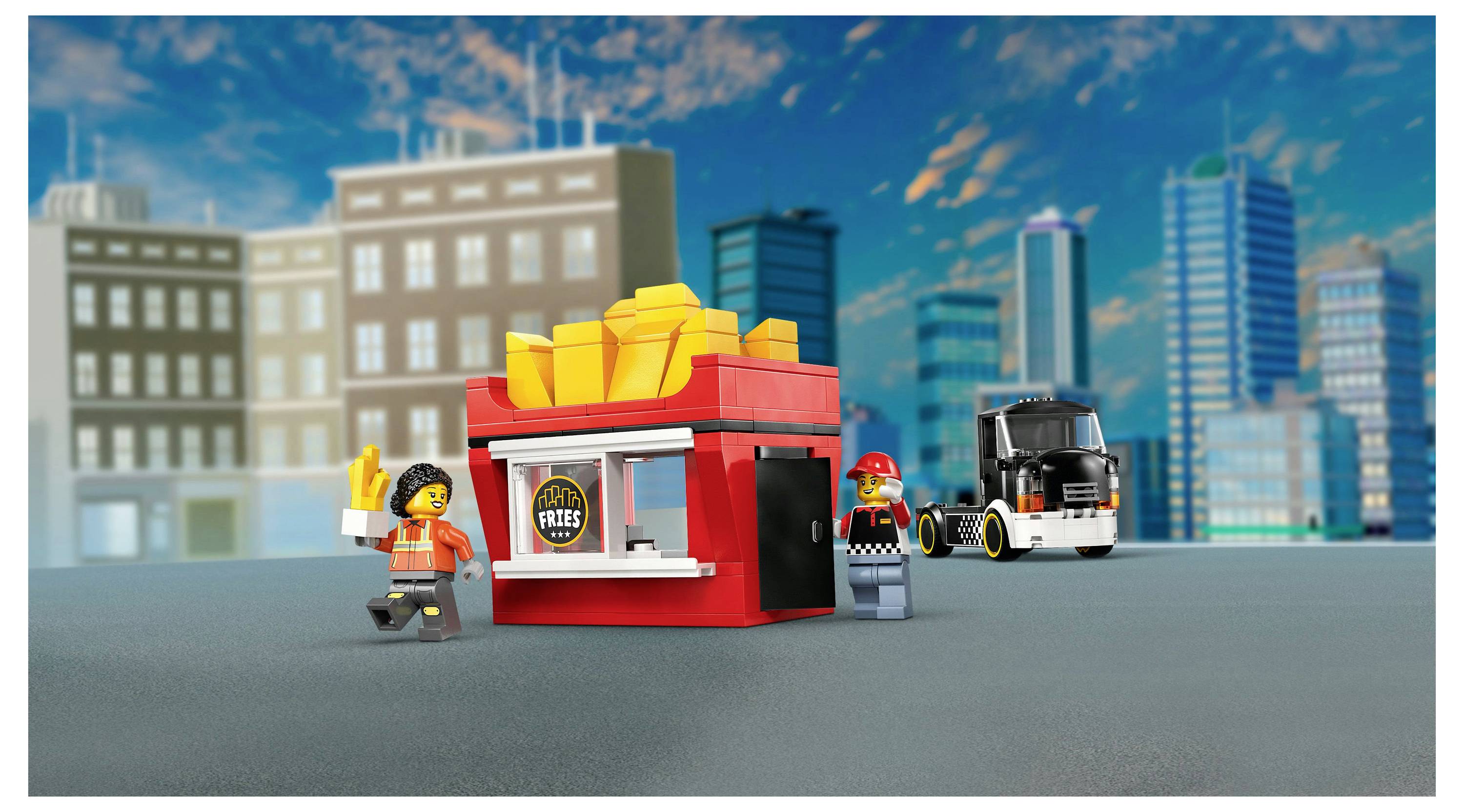 Toy figure with fries stand and truck, set in a cityscape. The stand has 'Street Fries' sign. Another toy figure stands nearby.