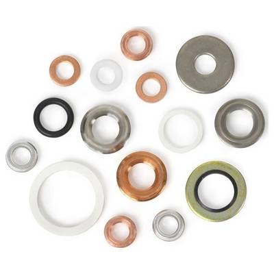 A variety of washers in different sizes and materials, including copper, rubber, and metal, arranged randomly on a white background.