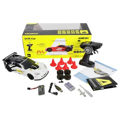 RC drift car kit includes a white model car, remote control, four extra tires, charger, batteries, cones, user manual, and packaging box.