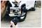 A person uses a smartphone mounted on a gimbal to record a white SUV parked on a driveway.
