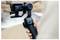 A person holds a camera stabilizer with a mounted action camera, capturing footage of a blurred outdoor background.