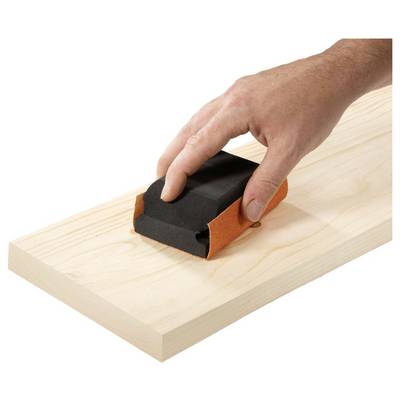 A hand sanding a piece of wood with a sanding block, showing a woodworking process.