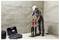 A worker in protective gear uses a core drill on a concrete floor, with equipment cases nearby in an unfinished room.
