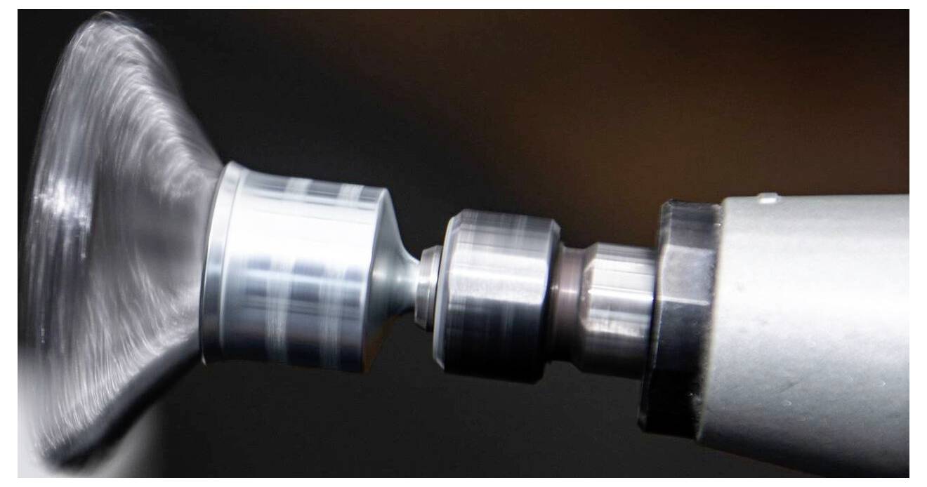 A metal or glass surface rotating rapidly on a lathe, showing details of mechanical precision and industrial craftsmanship.