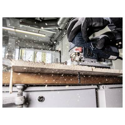 A person wearing gloves is cutting a wooden plank with a power saw, scattering sawdust in a workshop setting.