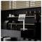 A modern cafe counter with a digital menu display showing coffee options. Shelves with cups and jars in the background.
