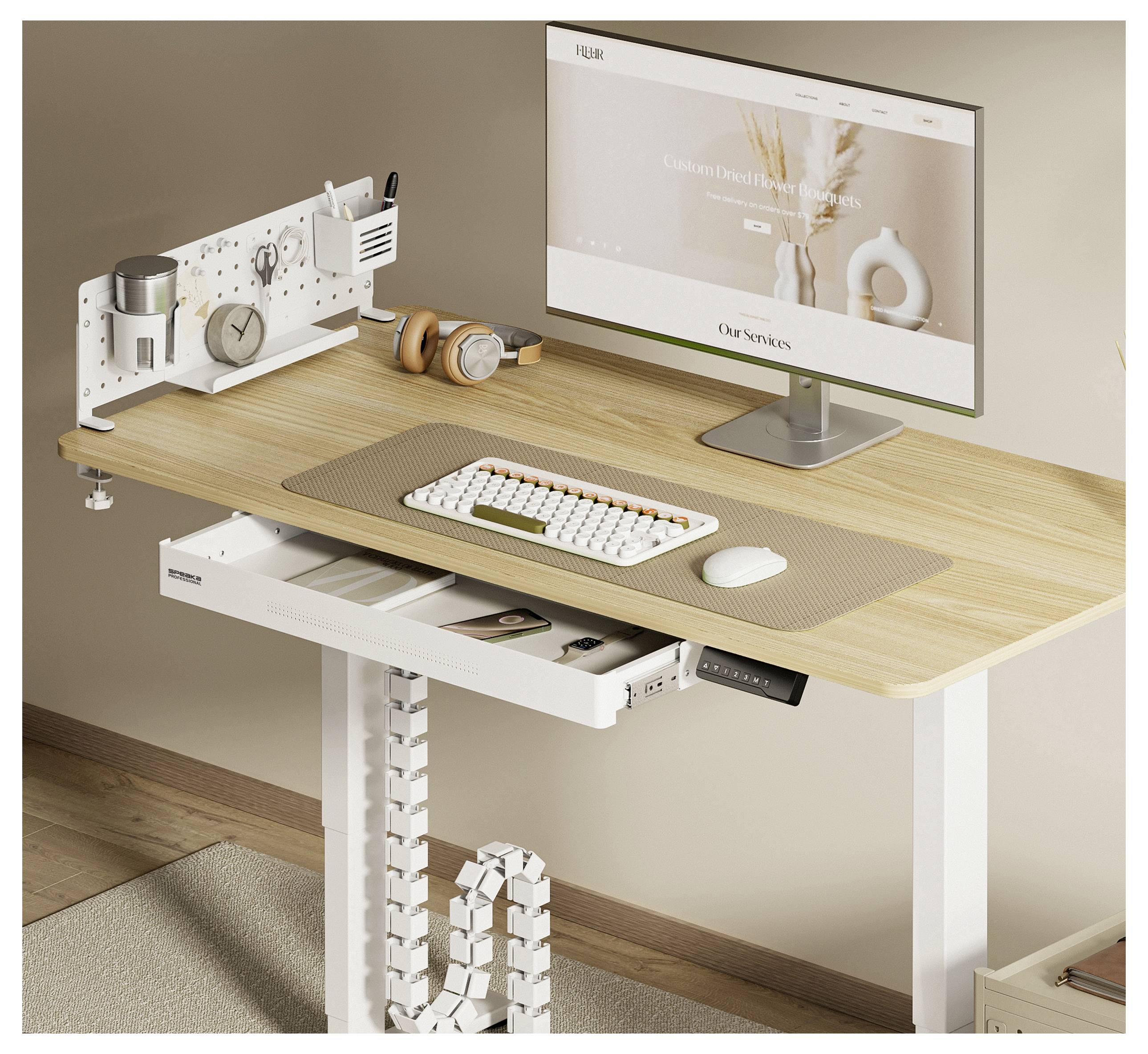 A modern workspace features a wooden sit-stand desk with a computer monitor displaying a website, keyboard, desktop organizer, and cable management.