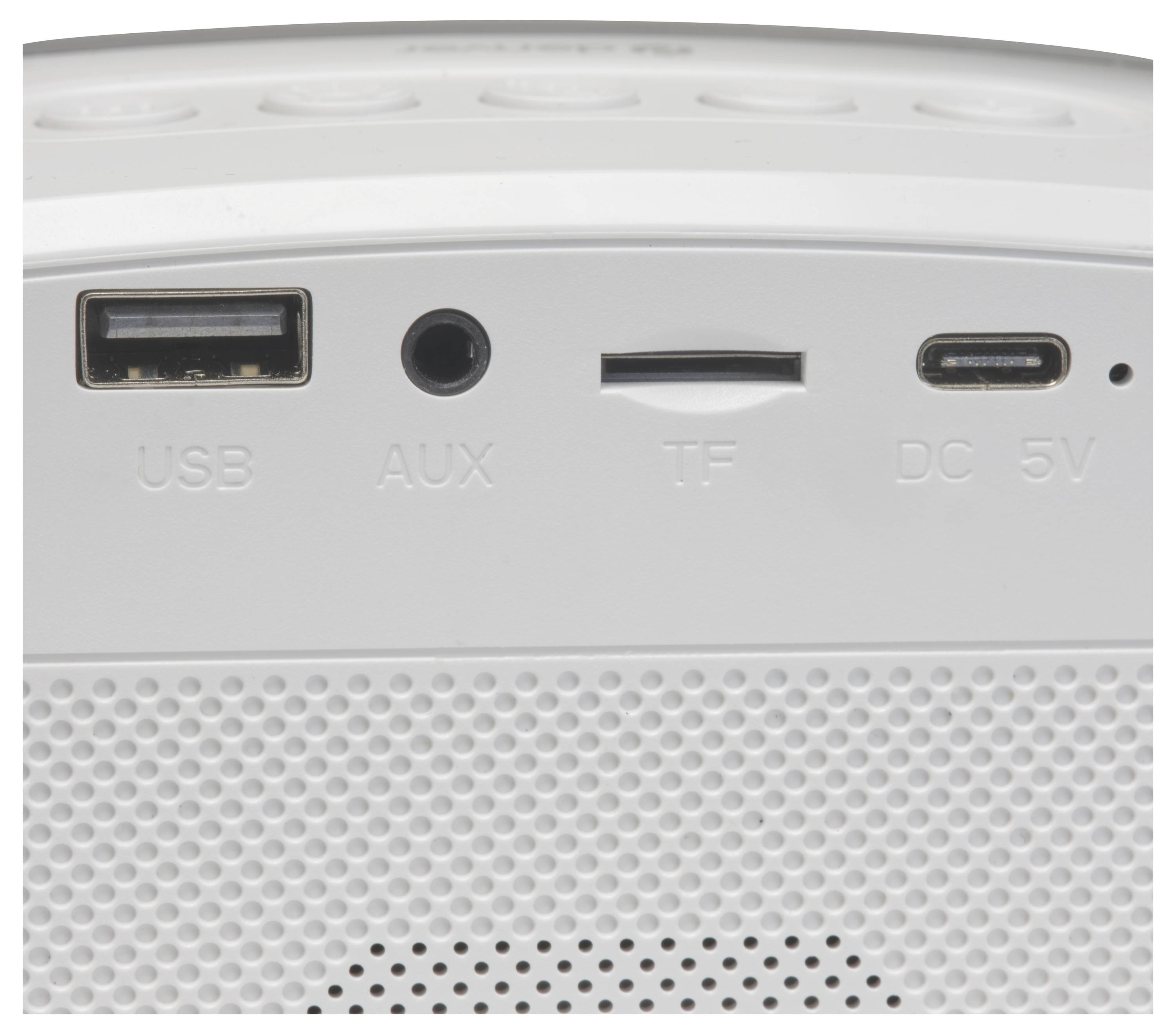 A close-up of a speaker showing four ports: USB, AUX, TF card slot, and DC 5V power input, indicating connectivity options.