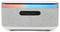 A gray rectangular speaker with LED lights on top, displaying a gradient from red to blue. Features include a USB port and audio input.