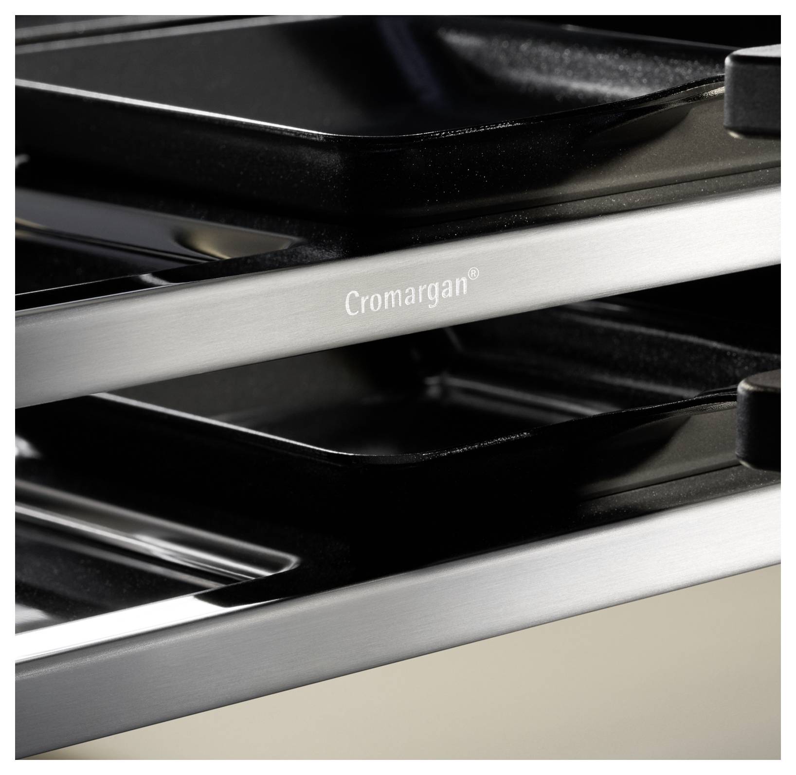 Close-up of kitchen racks with a stainless steel finish, labeled 'Cromargan'. Focus on sleek design and reflective surfaces.