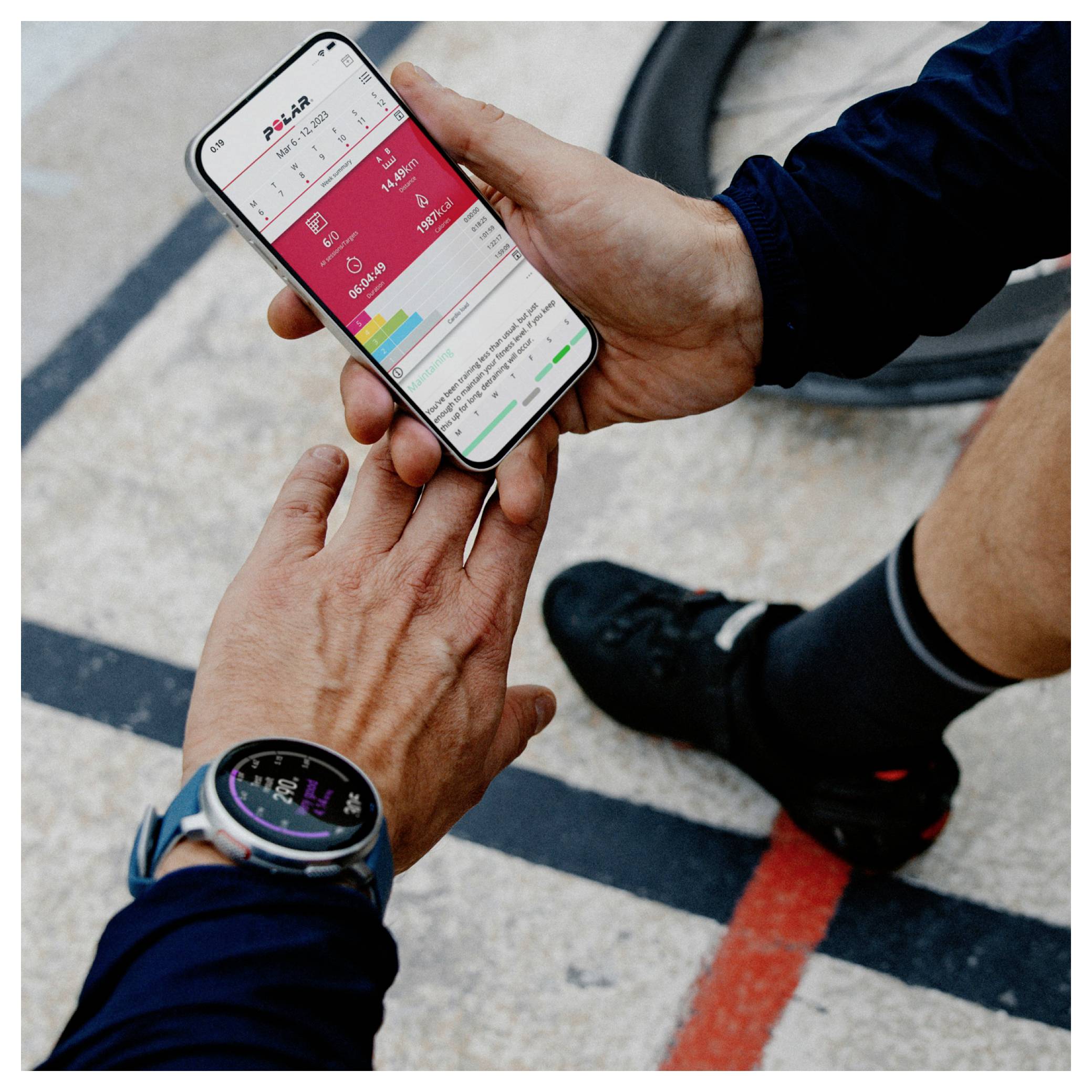 A person checks fitness data on a smartphone using a health app. Another person reaches to share or point at the screen.