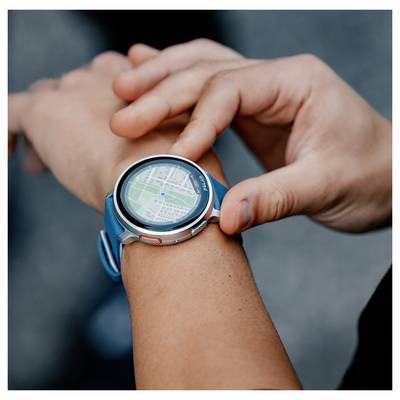 A person interacts with a smartwatch displaying a digital map featuring a location marker, suggesting navigation or tracking use.