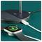 A smartwatch on a charging stand displays a battery icon with a lightning bolt, indicating charging in progress, connected via a USB cable.