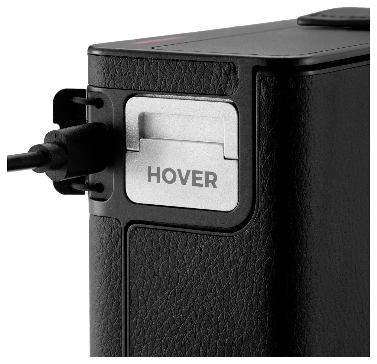 A close-up of a black leather-textured device with a port. The word 'HOVER' is printed on a silver component next to the port.