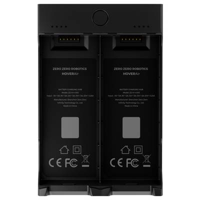 'HoverAir charging hub with dual battery slots and indicator lights, designed by Zero Zero Robotics. Labeled with model and safety symbols.'
